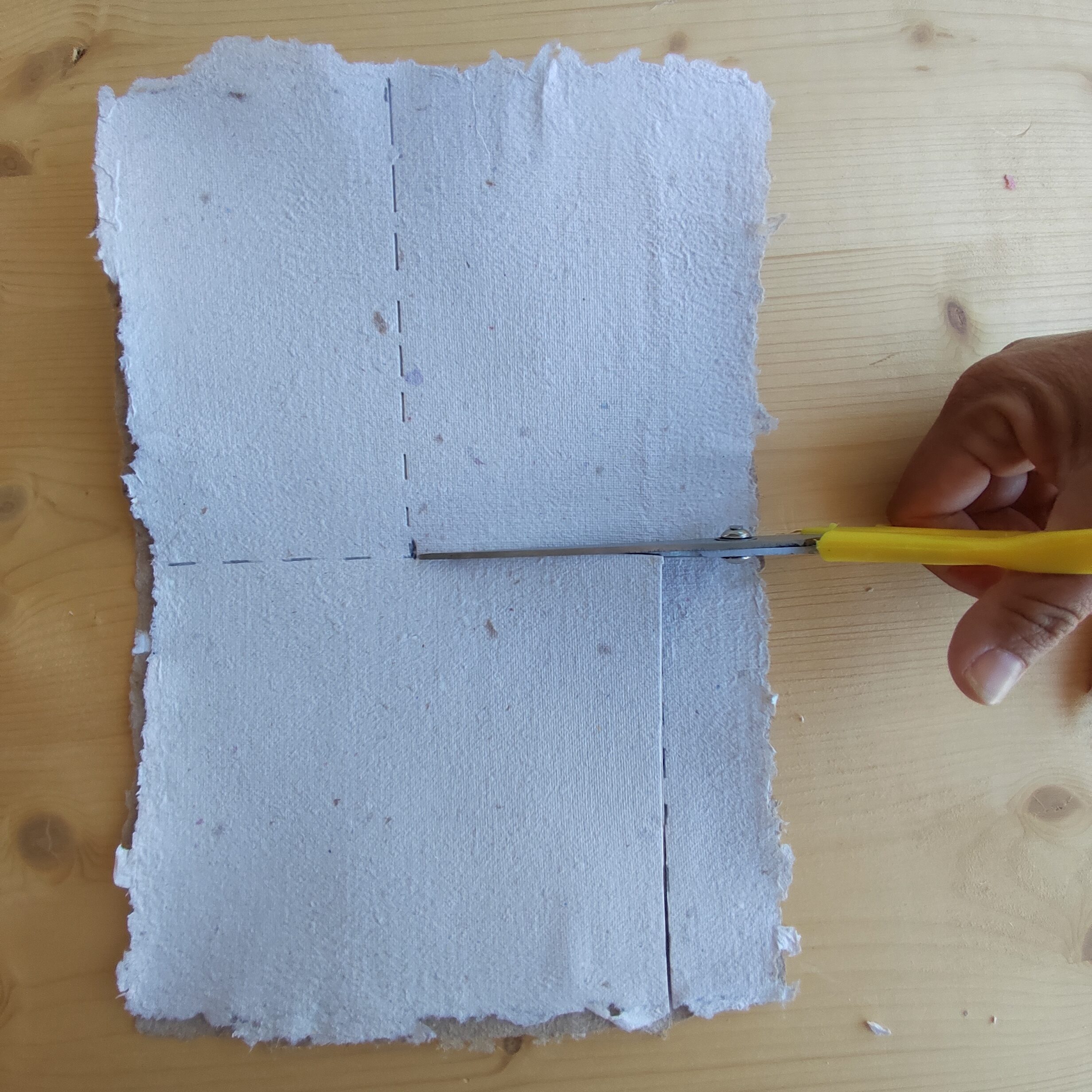 Foto tutorial busta di carta: sovrapponi due fogli A4, traccia due linee: la prima nella prima metà del foglio e la seconda, nella seconda metà del foglio. 