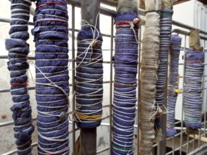 tessuto con foglie all'interno arrotolato a tubo e legato con filo per realizzare ecoprinting