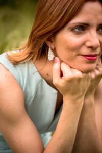 Donna elegante con orecchini creati con materiale riciclato dal design innovativo e sostenibile