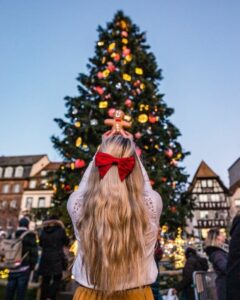 foto ragazza di spalle che fotografa albero di natale