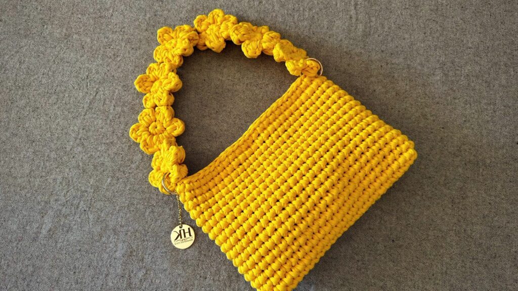 Borsa all'uncinetto gialla fatta a mano con tracolla decorata da fiori crochet