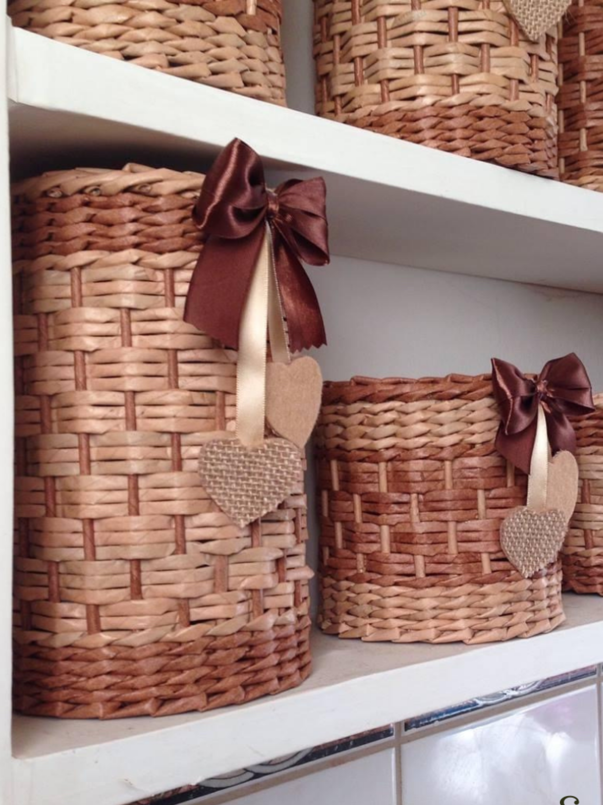 Mensola con cesti fatti a mano realizzati con la tecnica dell'intreccio e decorati con fiocco in tessuto