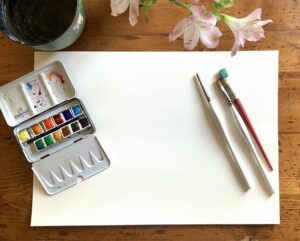 Foglio di carta, pennelli e colori acquerelli per dipengere