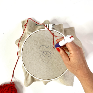 cuore con filo rosso infilato in punch needle