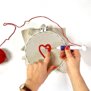 interno rosso del cuore con filo rosso infilato in punch needle
