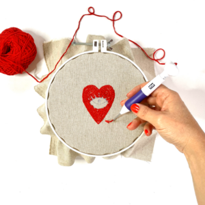 cuore rosso con filo rosso infilato in punch needle