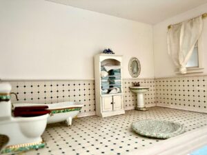 Bagno in miniatura di una casa delle bambole con vasca, lavabo e mobili