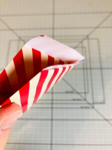 Piano da lavoro con foglio di carta da regalo a strisce bianche e rosse piegato