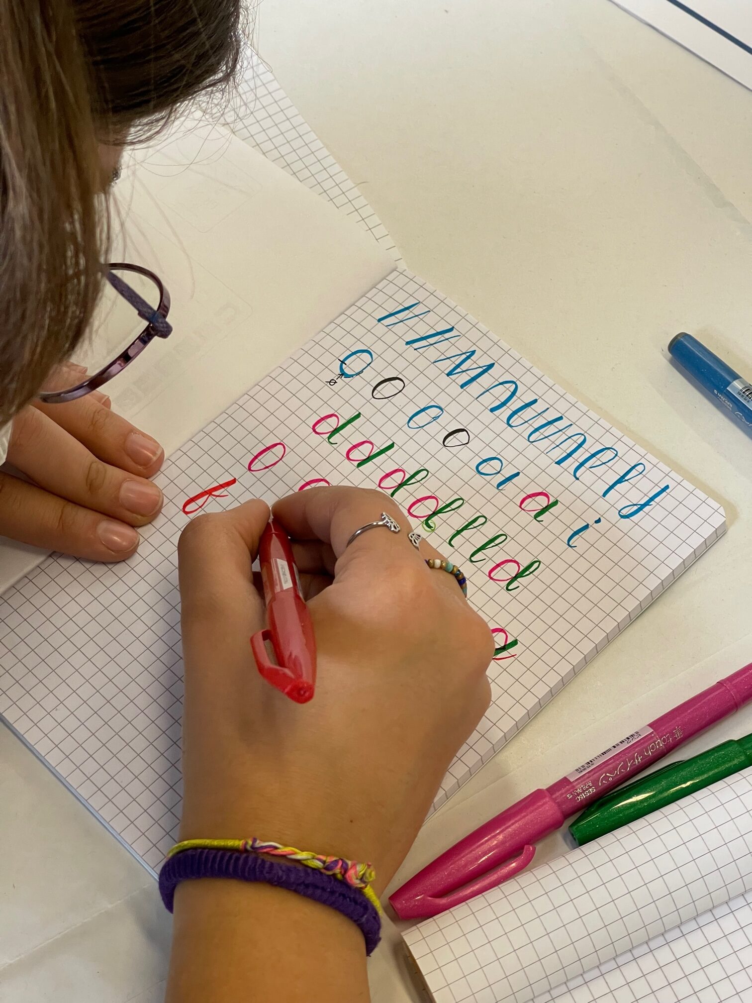 persona che scrive diverse lettere colorate con la tecnica del brush lettering per imparare