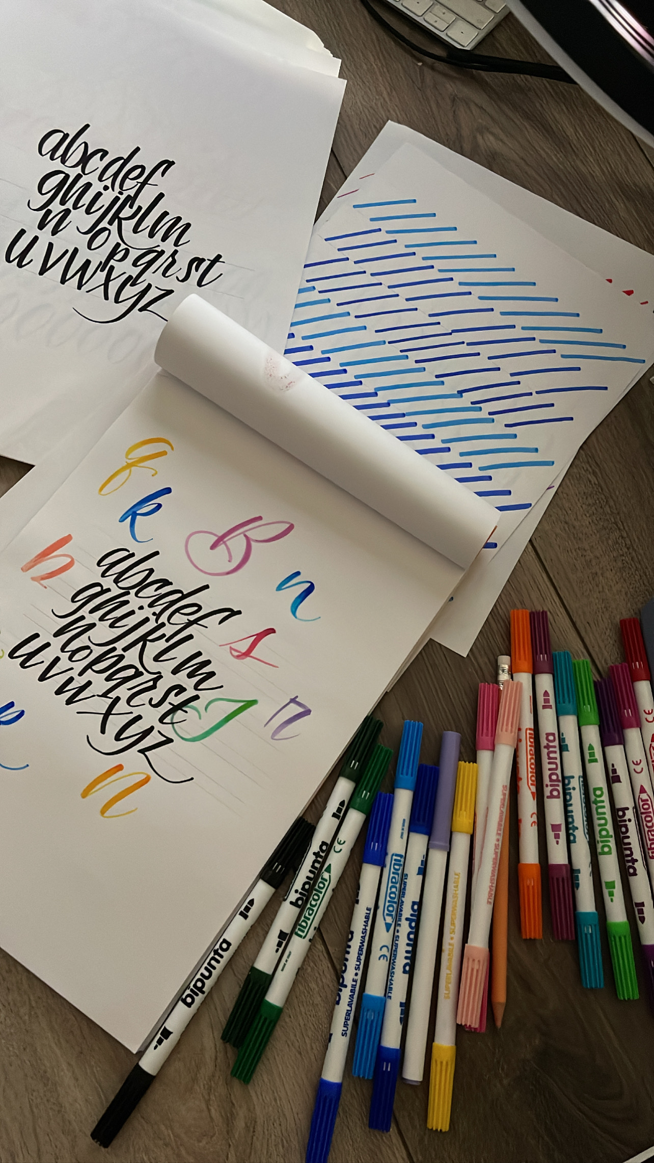 piano di lavoro per esercitarsi con il brush lettering con pennarelli e fogli