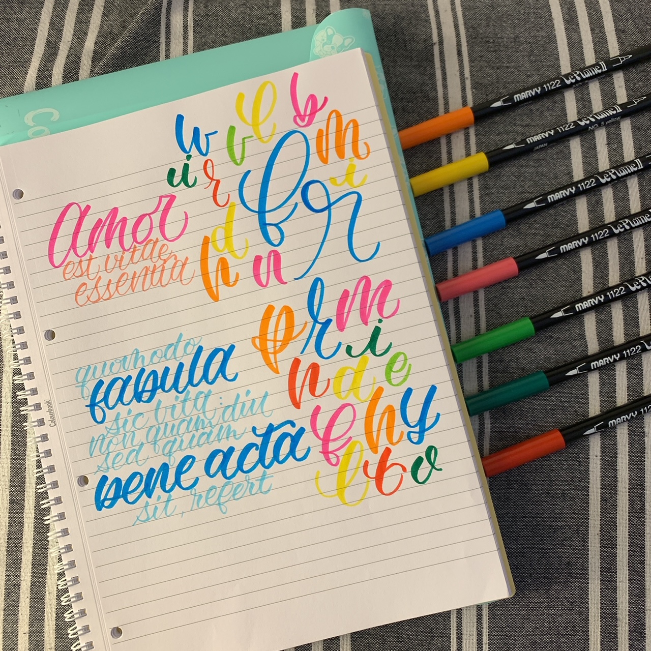 piano di lavoro con quaderno e pennarelli per allenarsi con il brush lettering 