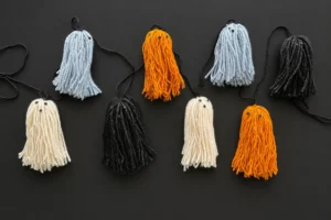 Ghirlanda di fantasmini di lana bianchi arancioni neri e grigio azzurri per Halloween