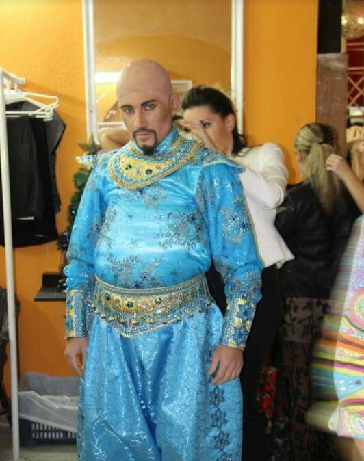 Persona travestita da Aladin con vestito azzurro e sarta che sistema vestito nel backstage dello spettacolo