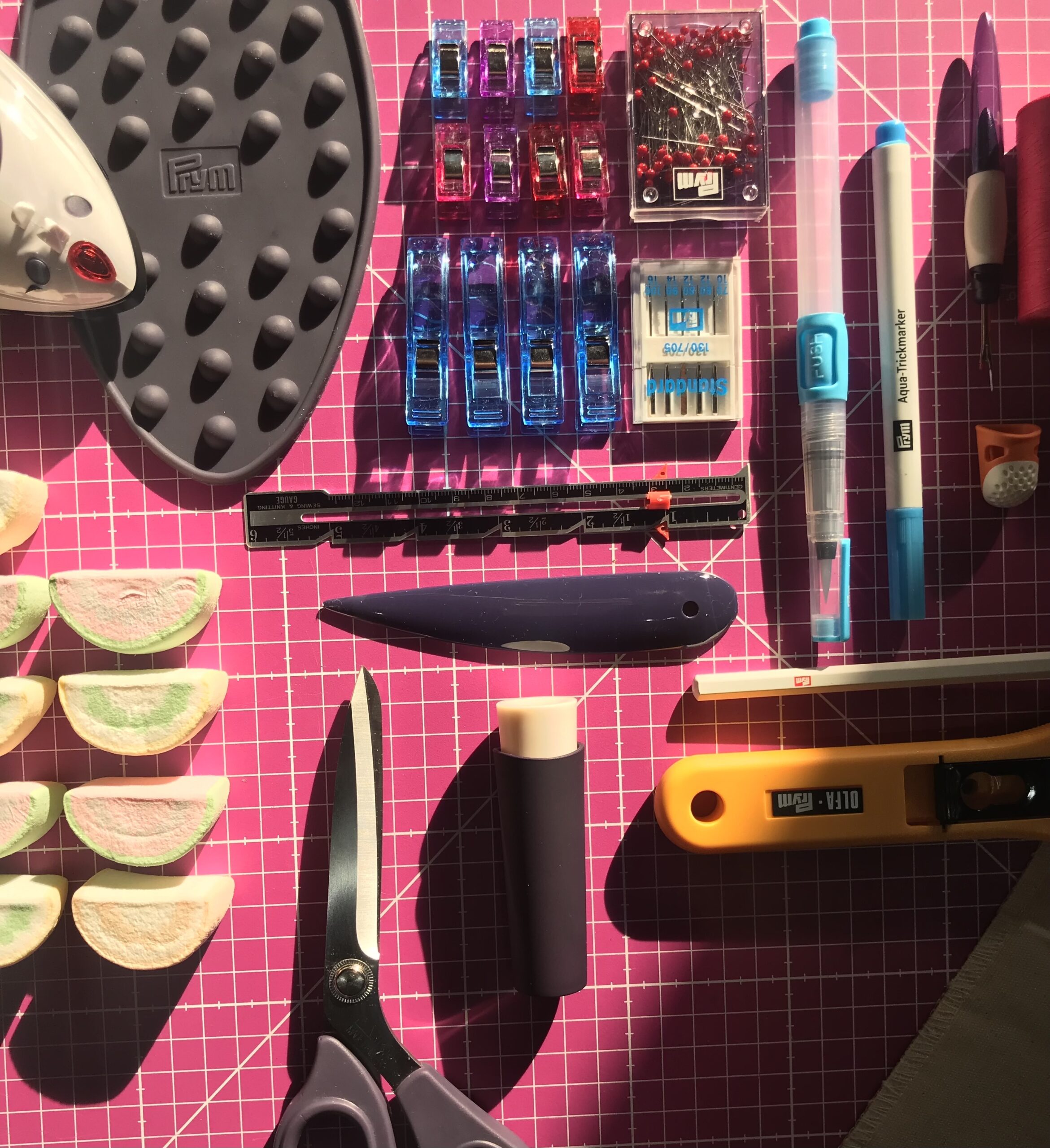 Piano di lavoro con materiali per cucire come forbici, penne, aghi e filo
