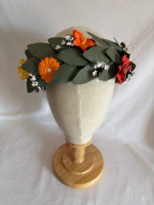 Corona d'alloro di carta con foglie e fiori arancioni e bianchi
