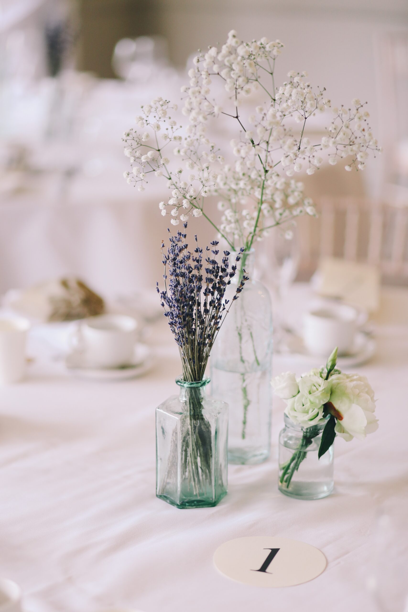 Centro tavola elegante con vaso bianco e fiori bianchi e lilla