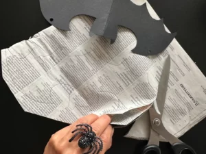 Ritaglio di pipistrelli di Halloween sulla carta di giornale seguendo una sagoma