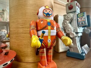 Robot giocattolo vintage in latta, tra cui uno Strand Robot con fucile a raggi