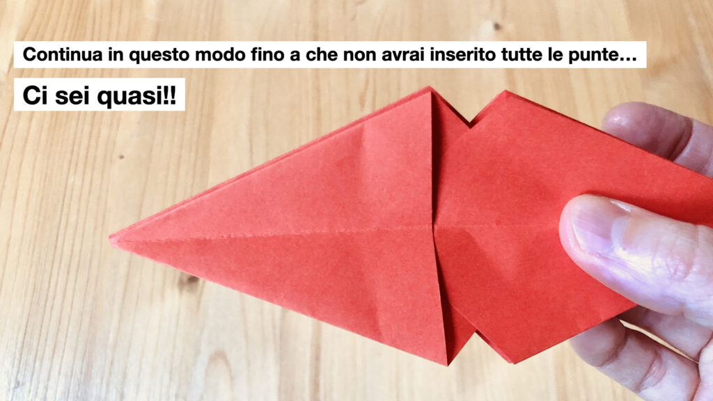 mano con decorazioni in carta di Natale fai-da-te